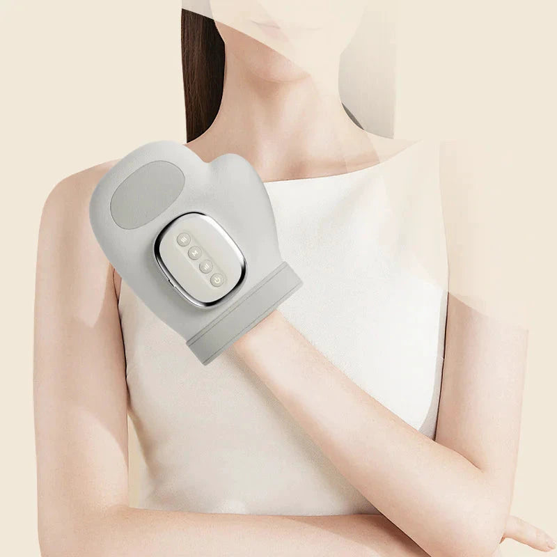 Gray wireless wrist massager strapped to a hand; silver control panel with four buttons, beige background.